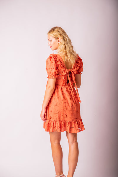 Oranžové madeirové šaty s mašľou odfotené zozadu